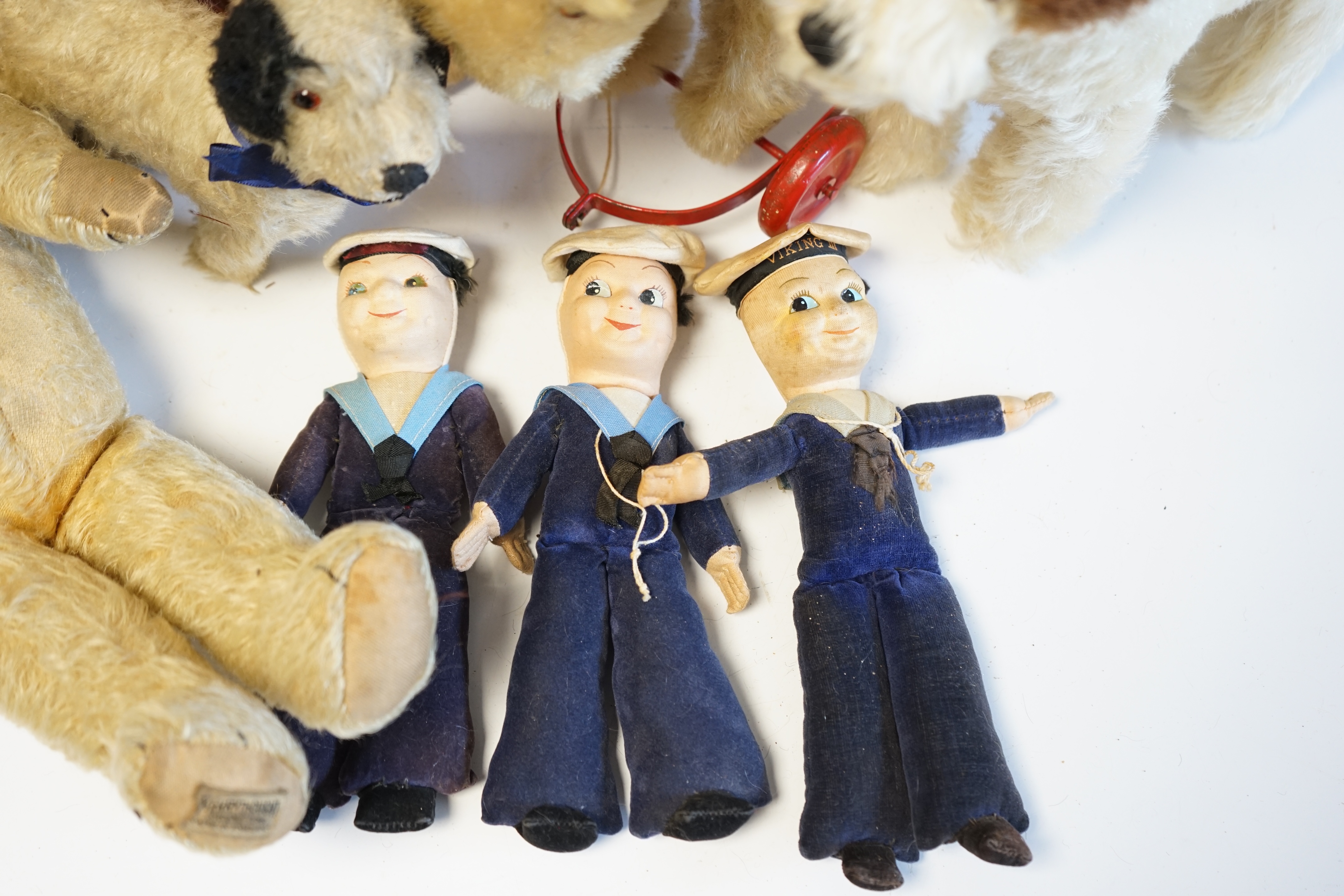 A Schuco Bigo Bello dog 'Lady', with collar and label, three Norah Wellings sailor dolls, four other toys, a 1930's Merrythought Teddy, with button and label, some hair loss, and a Merrythought dog on wheels (10). Condit